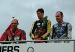 Ian Hutchinson (centre) on winners podium at Grandstand.